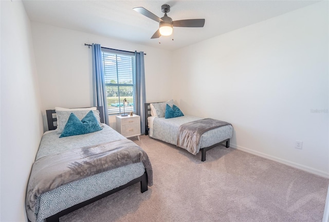 bedroom with light colored carpet, ceiling fan, and baseboards