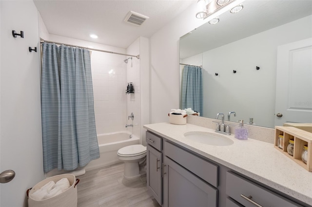 bathroom featuring toilet, shower / bath combo with shower curtain, vanity, and visible vents