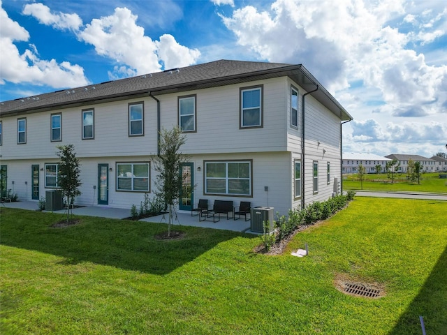 rear view of property featuring cooling unit, a patio area, and a yard