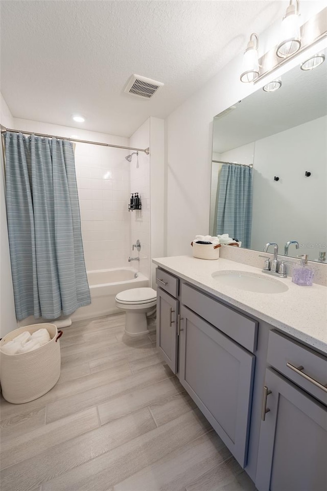 full bath with visible vents, toilet, shower / bath combo, a textured ceiling, and wood finished floors