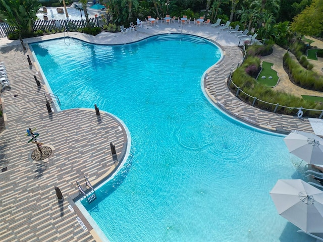 pool with a patio and fence