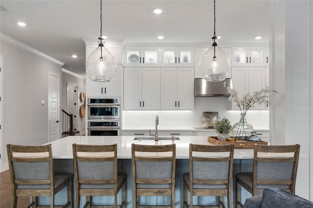 kitchen featuring a sink, crown molding, double oven, white cabinetry, and backsplash