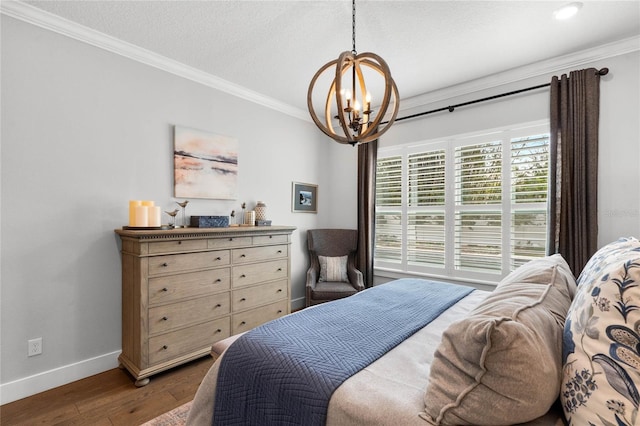 bedroom with ornamental molding, an inviting chandelier, baseboards, and wood finished floors