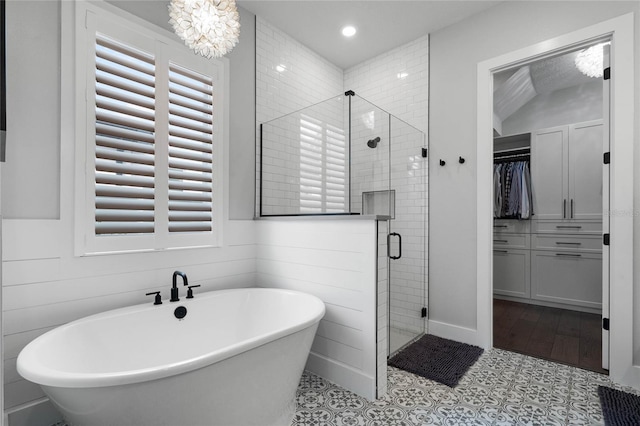 full bathroom featuring a soaking tub, tile patterned floors, a spacious closet, a shower stall, and recessed lighting