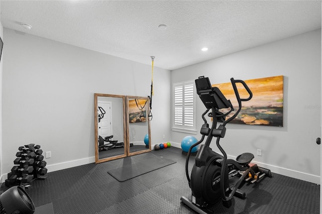 exercise room featuring recessed lighting, a textured ceiling, and baseboards