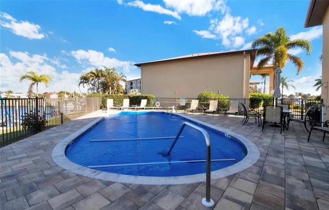 pool with a patio area and fence