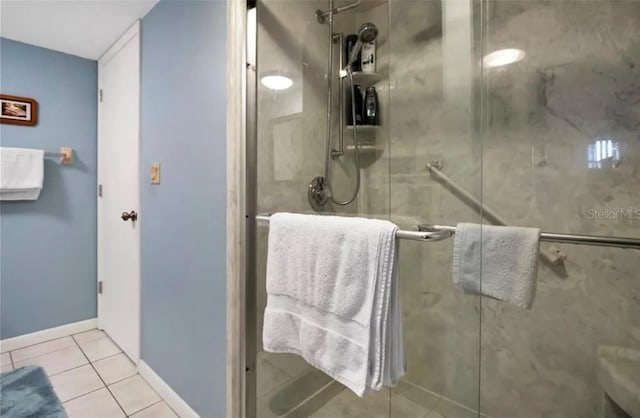 full bath featuring tile patterned flooring, a shower stall, and baseboards