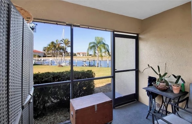 sunroom featuring a water view