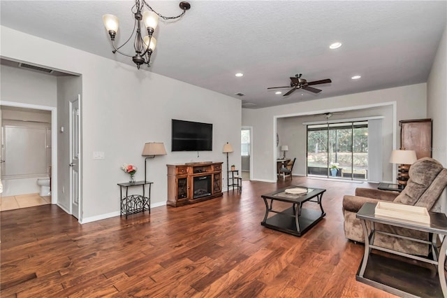 living area featuring a textured ceiling, ceiling fan with notable chandelier, wood finished floors, and recessed lighting