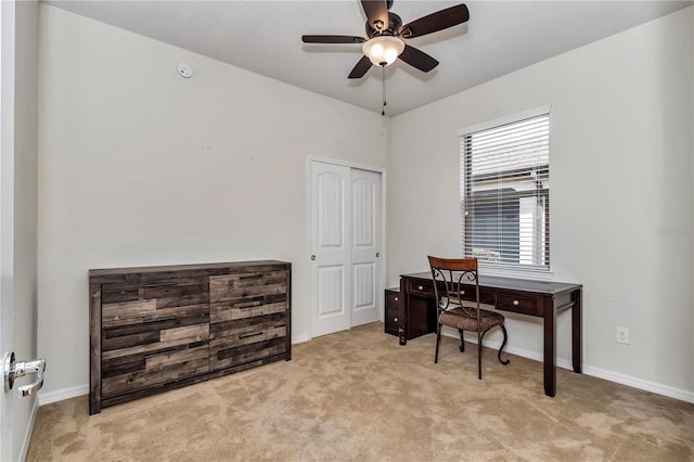 office area featuring a ceiling fan, light carpet, and baseboards