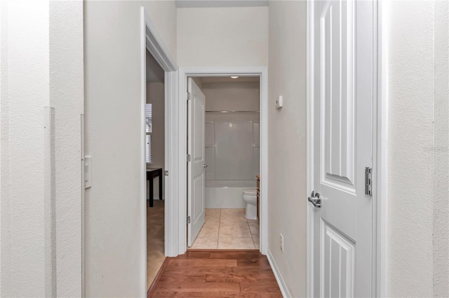 hallway with baseboards and wood finished floors