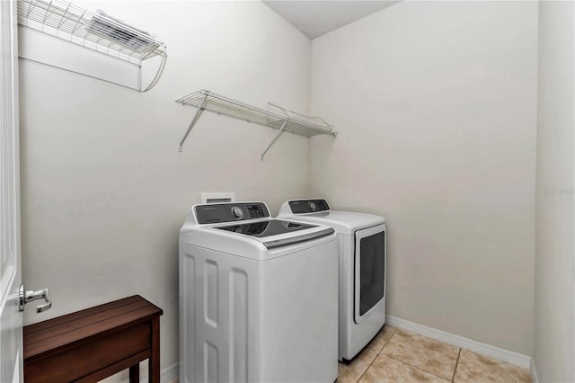 washroom with washer and dryer, laundry area, baseboards, and light tile patterned floors