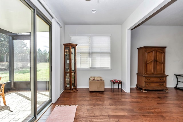 living area with baseboards and wood finished floors