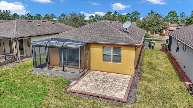 back of house with stucco siding, a shingled roof, a lawn, and a patio