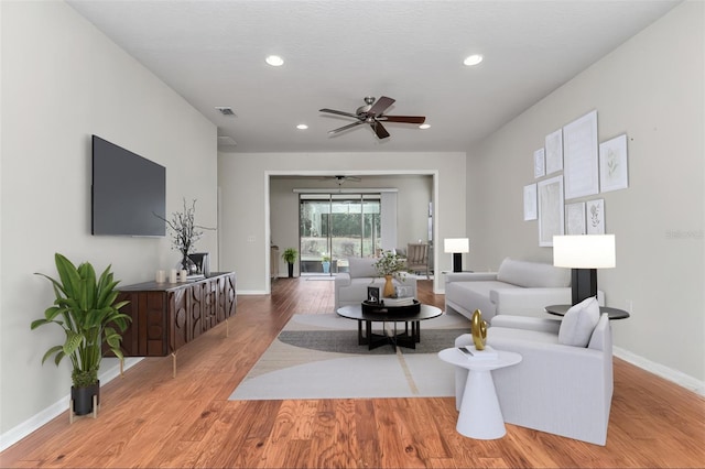 living area featuring visible vents, baseboards, ceiling fan, wood finished floors, and recessed lighting