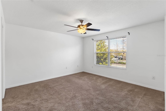 unfurnished room with carpet, baseboards, ceiling fan, and a textured ceiling