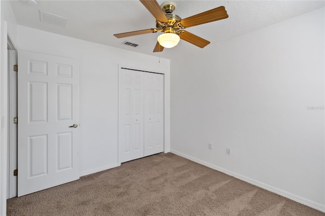 unfurnished bedroom with light carpet, a closet, visible vents, and baseboards