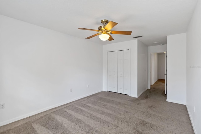 unfurnished bedroom featuring light colored carpet, a closet, visible vents, and baseboards