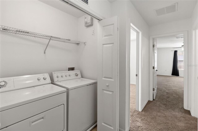 laundry area featuring light colored carpet, laundry area, visible vents, baseboards, and washer and dryer