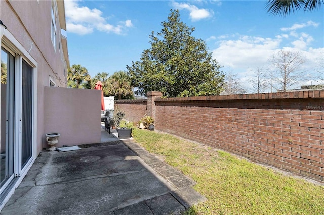 view of yard with fence and a patio