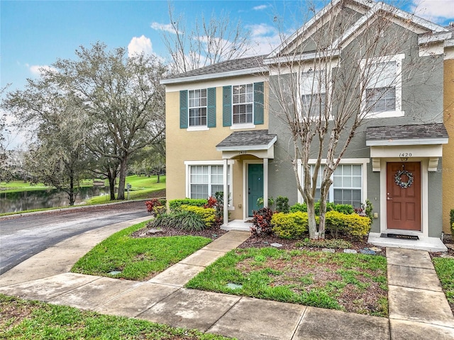 townhome / multi-family property with a shingled roof and stucco siding