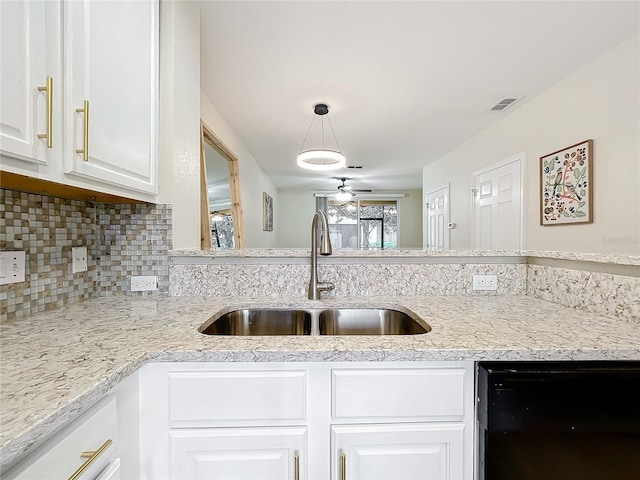 1410 Stockton Dr, Sanford, FL 32771 - kitchen featuring visible vents, a sink, decorative backsplash, and white cabinetry