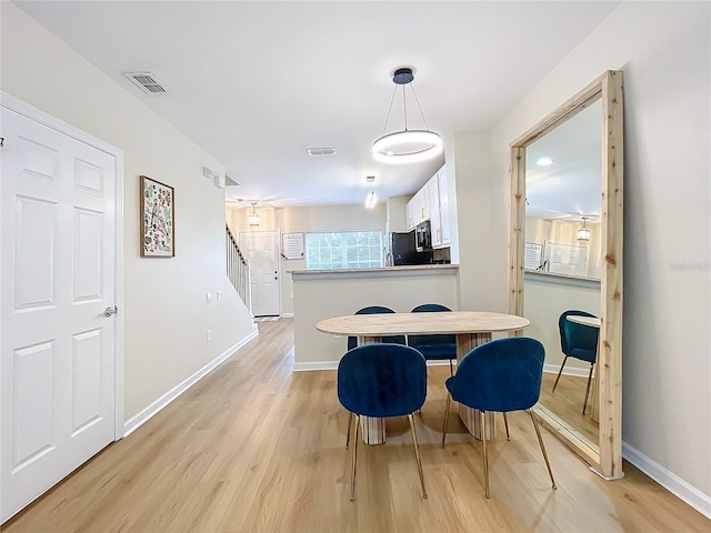 1410 Stockton Dr, Sanford, FL 32771 - dining room with light wood-type flooring, visible vents, baseboards, and stairs