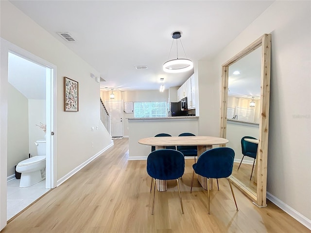 1410 Stockton Dr, Sanford, FL 32771 - dining area featuring stairs, light wood finished floors, visible vents, and baseboards