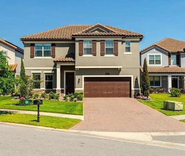 view of front of house with decorative driveway, stucco siding, an attached garage, a front yard, and cooling unit