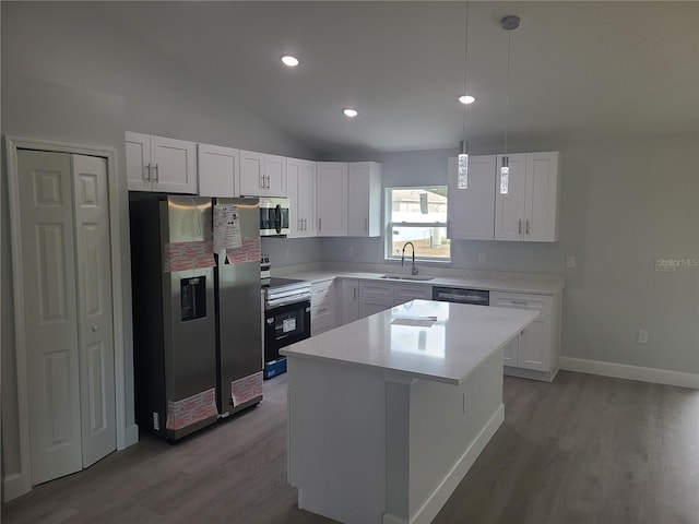 kitchen with white cabinets, stainless steel appliances, light countertops, and a center island