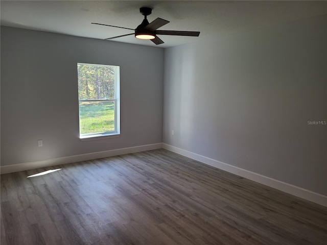 empty room with a ceiling fan, baseboards, and wood finished floors