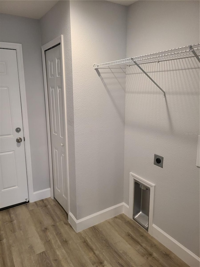 laundry room with baseboards, electric dryer hookup, and wood finished floors