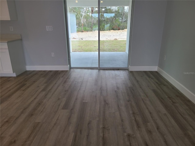 interior space with baseboards and dark wood finished floors