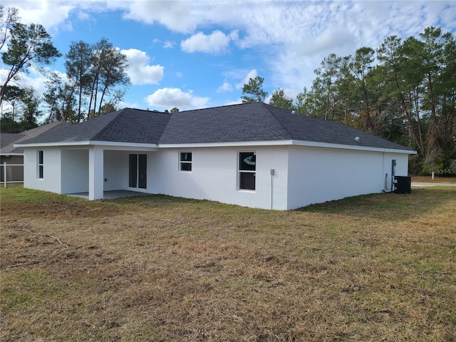 rear view of house featuring a patio, a lawn, stucco siding, and central air condition unit