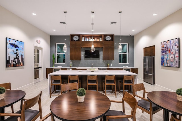 dining space with light wood-style flooring, visible vents, and recessed lighting