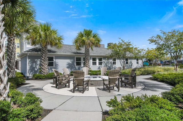 rear view of property with a patio area and a fire pit