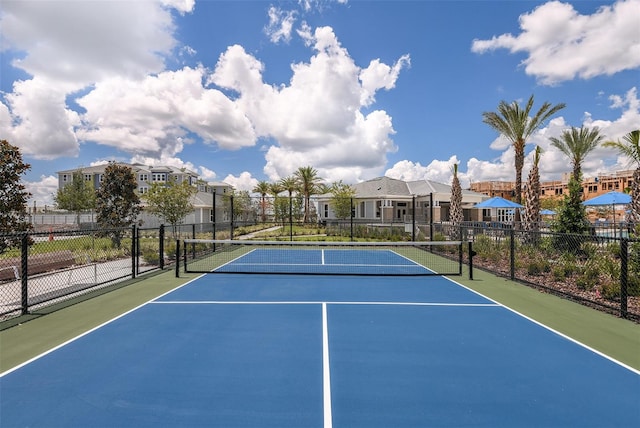 view of sport court with a residential view and fence