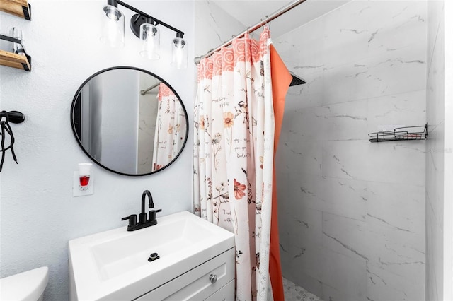 bathroom with a shower stall, toilet, and vanity