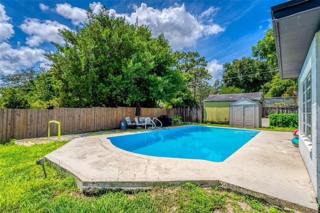 view of pool featuring an outbuilding, a patio, a storage unit, and a fenced backyard