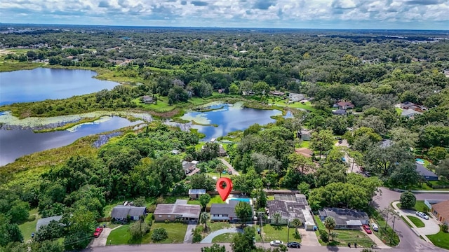 birds eye view of property with a water view and a wooded view