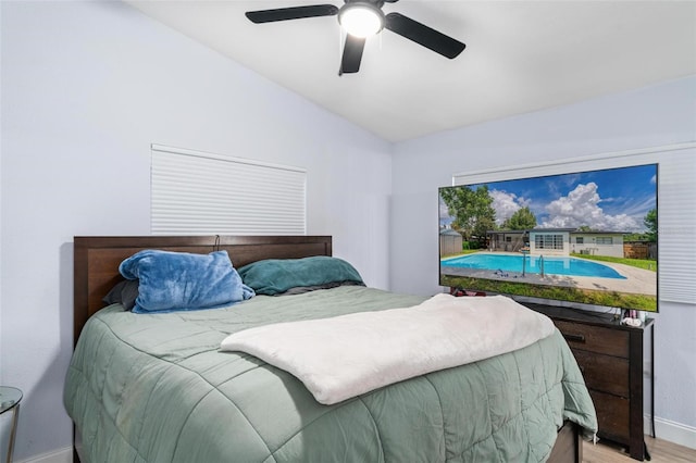 bedroom with lofted ceiling, ceiling fan, wood finished floors, and baseboards