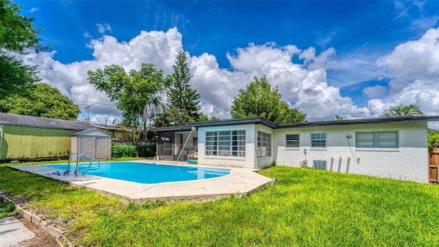 exterior space featuring an outbuilding, a sunroom, a yard, a fenced in pool, and a storage unit