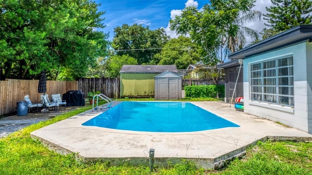 view of swimming pool with a storage unit, a patio area, and a fenced backyard