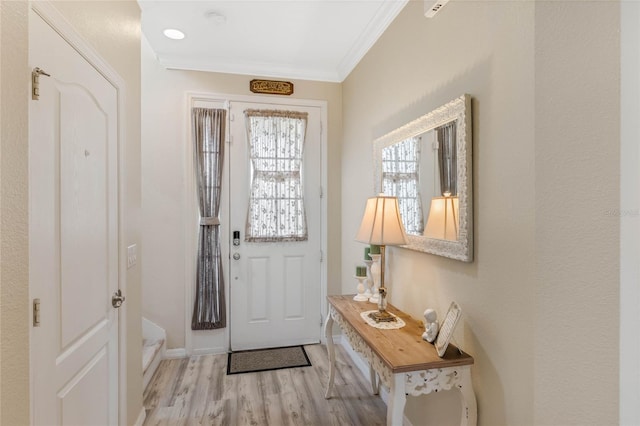 entrance foyer featuring ornamental molding and wood finished floors