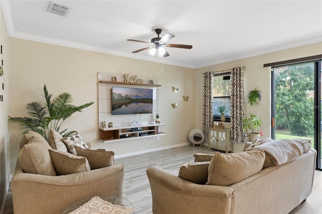 living area featuring baseboards, visible vents, ceiling fan, ornamental molding, and wood finished floors