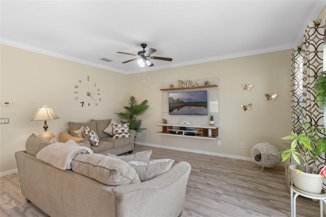 living room with ornamental molding, visible vents, baseboards, and wood finished floors