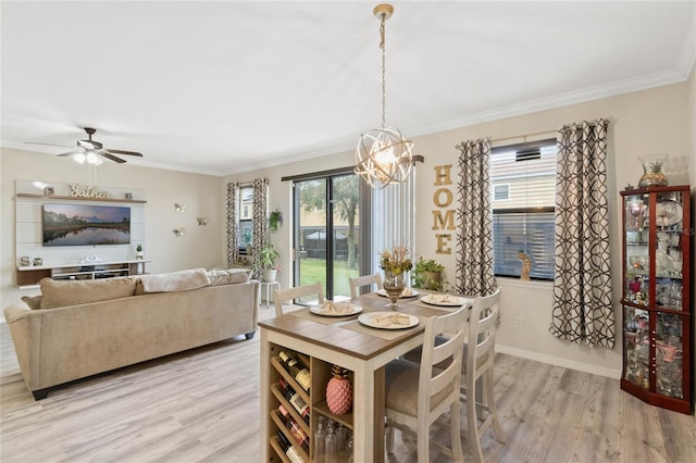 dining area with ornamental molding, light wood finished floors, and baseboards