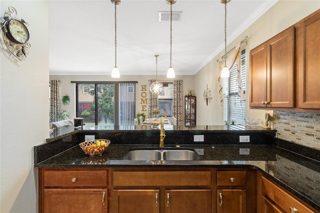 kitchen featuring backsplash, plenty of natural light, a sink, and visible vents