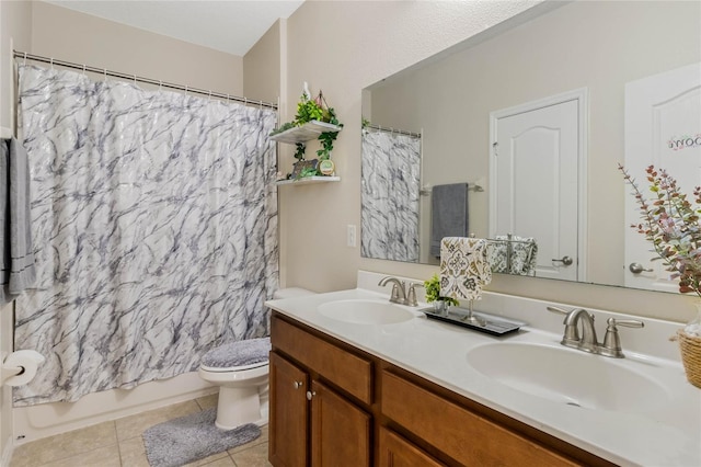 bathroom featuring double vanity, a sink, toilet, and tile patterned floors