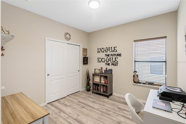 office area featuring light wood-type flooring and baseboards